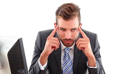 serious-businessman-getting-headache-at-desk